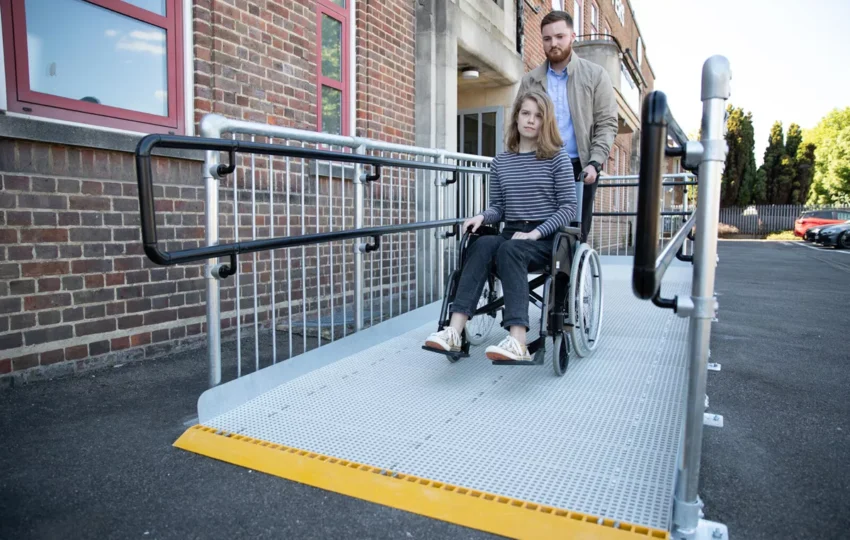 a man helping a girl on a wheel chair