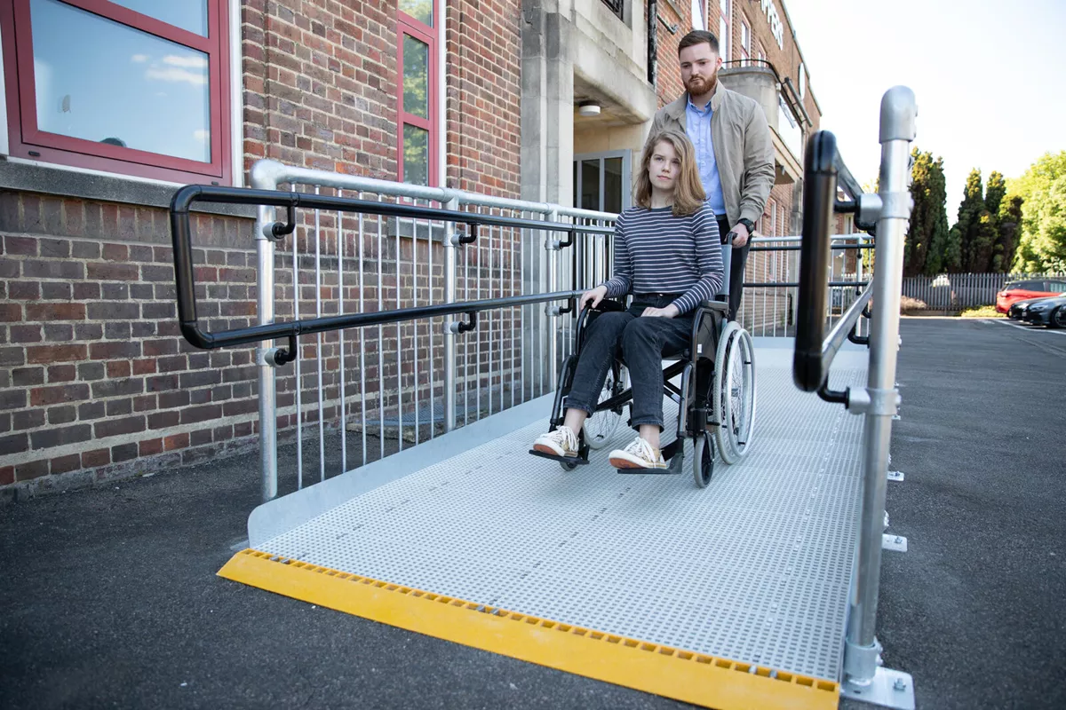 a man helping a girl on a wheel chair