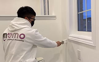 man-painting-white-paint-in-a-wall